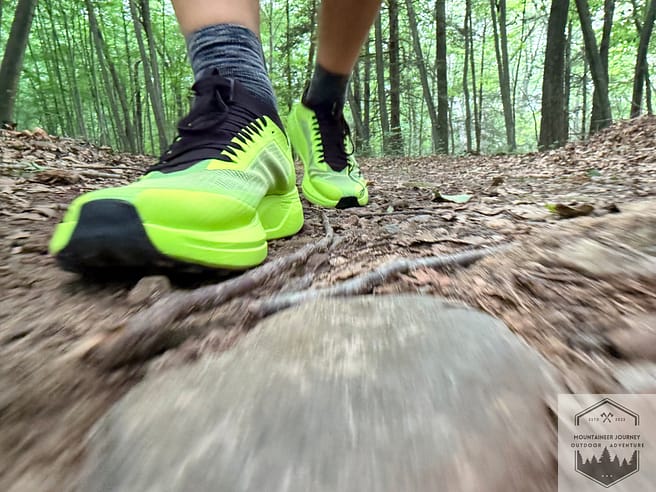 Action shot of the Arc'teryx Sylan 2s on rock-covered and root-covered trails during testing.