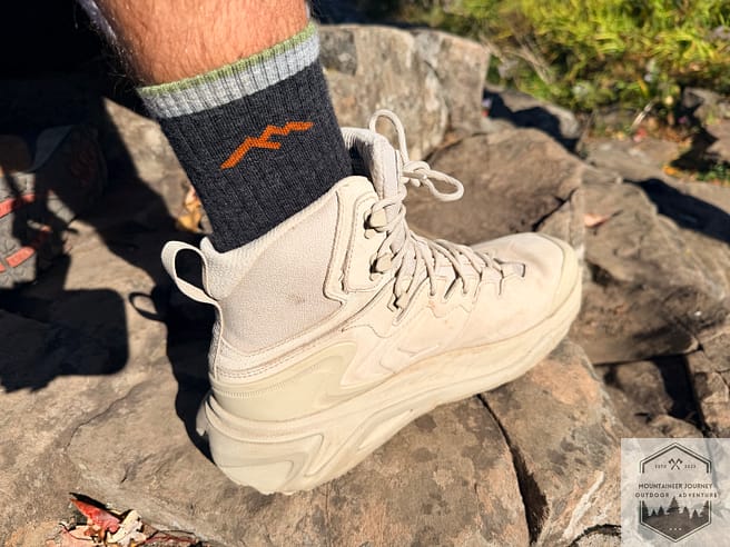Standing on rocks with Hoka Kaha 3, view of the TPU shank on the heel of the boot