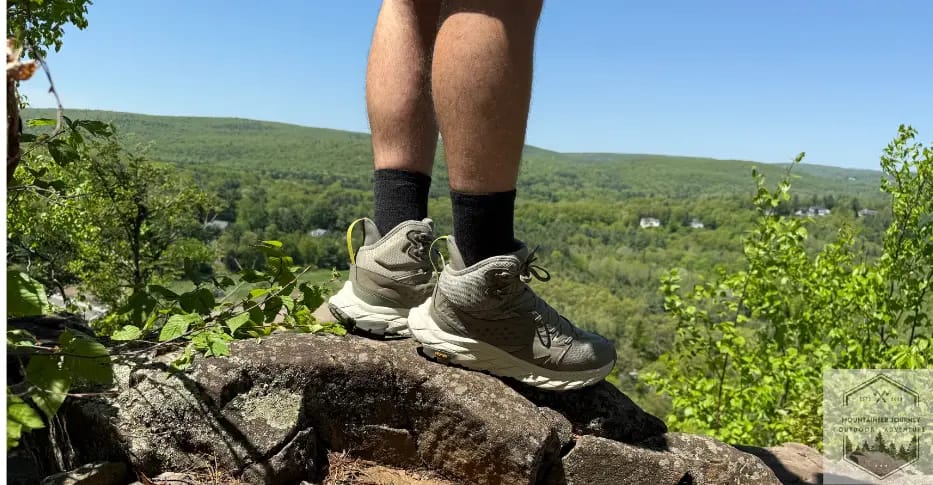 wearing hiking boots on a rock, showing the "mid" portion of the boot