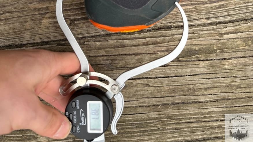 Measuring the Altra Lone Peak 9+ toe box with a digital caliper at 3.87 inches to verify wide width and foot splay room.