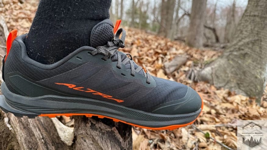 Right-sided profile of the Altra Lone Peak 9+ on a log, showing the zero-drop platform and Altra EGO midsole stack height.