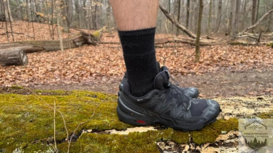 blog-img-1744747844304 Actively testing the Salomon Speedcross 6 stability on a fallen tree log to evaluate the shoe's lateral control and ground feel during technical off-trail maneuvers