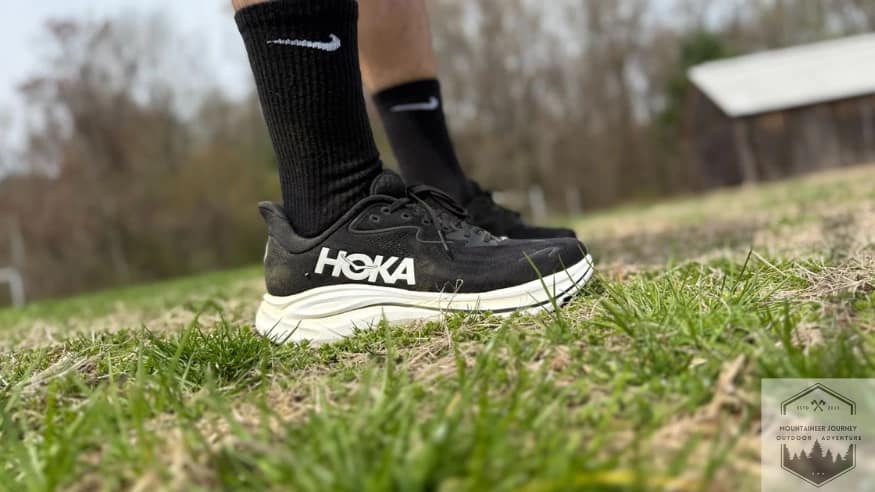 Side view of the hoka clifton 10, wearing in grass during testing
