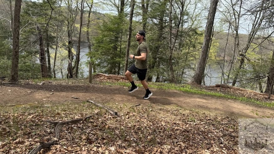 Running on a dirt trail in Hoka Clifton shoes to test traction and stability