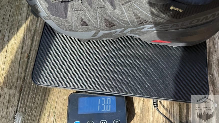 Weighing the Salomon Speedcross 6 on a digital scale at 13 oz providing verified technical specifications for this aggressive mountain trail runner.
