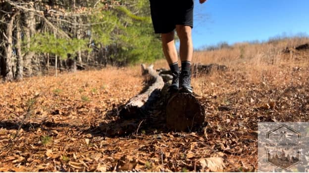 blog-img-1732723216899 standing on a log holding balance with the hiking shoes
