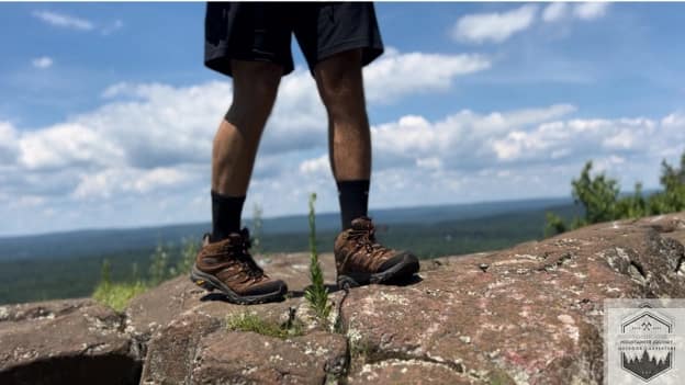 blog-img-1721426584274 Frontal view of the Merrell Moab 3 at the mountain summit, showcasing the reinforced rubber toe cap and performance pig suede overlays for superior protection against trail debris.