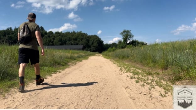 Testing the Salomon Quest 4 GTX on a sandy path, green grass to right and left