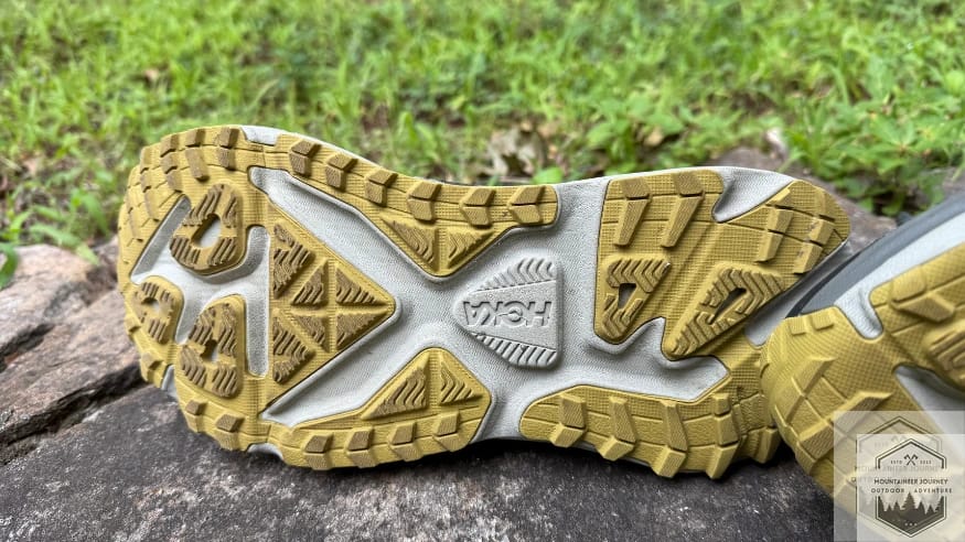 Bottom view of the Hoka Stinson 7 outsole highlighting the 4mm multi-directional lugs and the wide-base Durabrasion rubber for road-to-trail use.