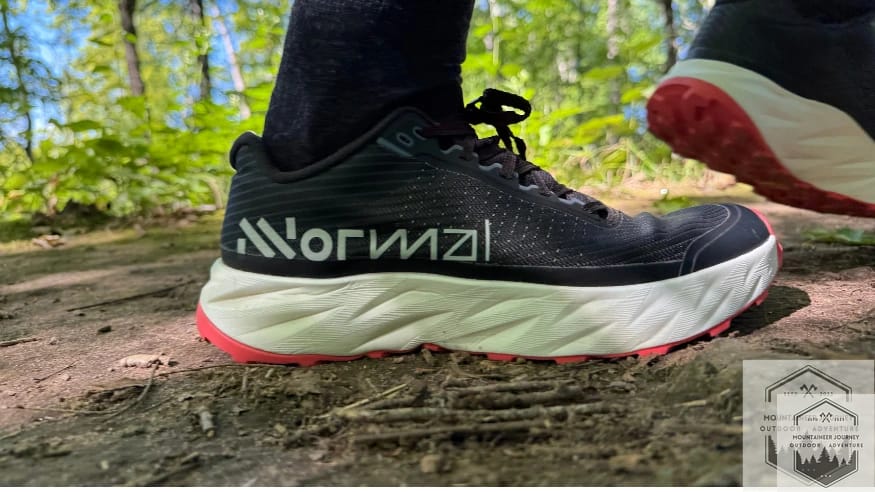 Side view of NNormal Kjerag 2 on dirt trail highlighting the rockered sole geometry