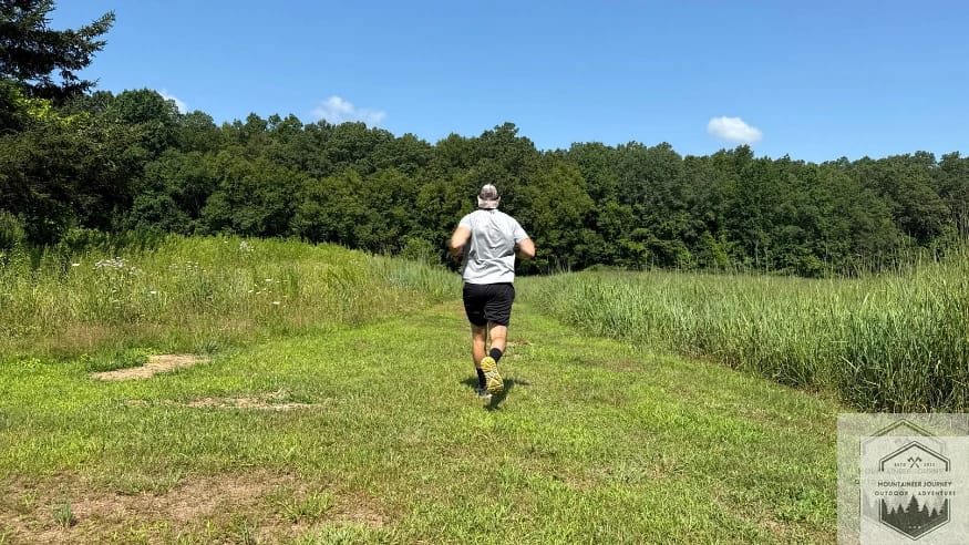 Action shot of the Hoka Stinson 7 demonstrating the Late-Stage Meta-Rocker during a smooth heel-to-toe transition on a smooth trail