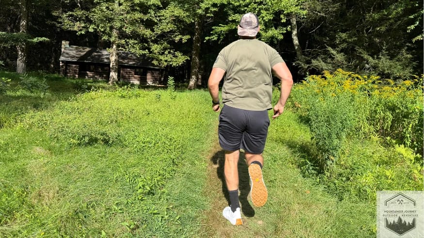 Running on a dirt covered path testing the Norda 001 trail shoe