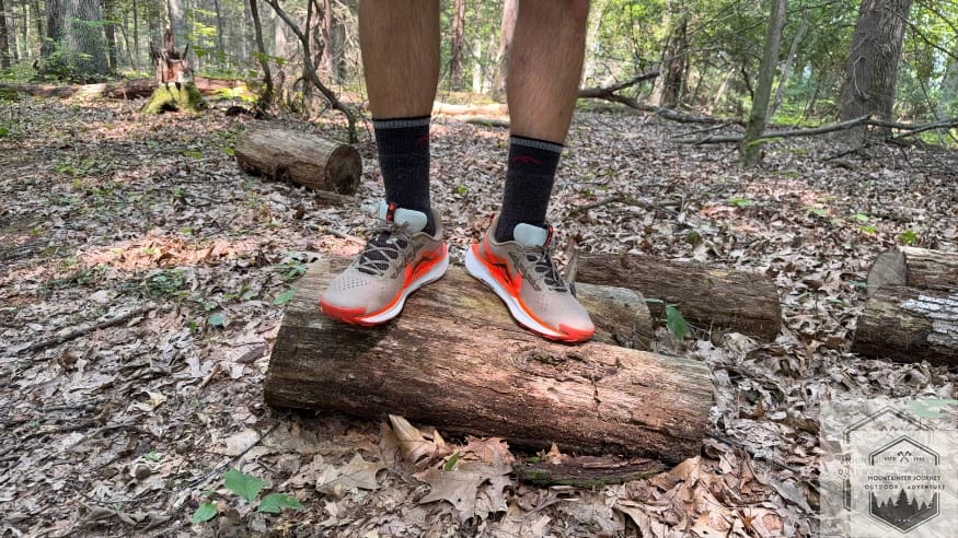 Standing on a log wearing the Nike Pegasus Trail 5, showing the stack height