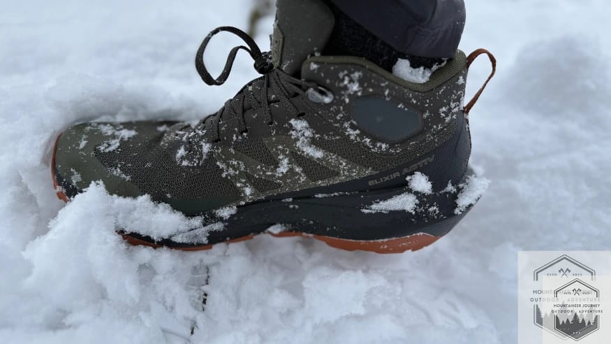 Salomon Elixir Activ completely submerged in snow during waterproof testing with zero leakage.