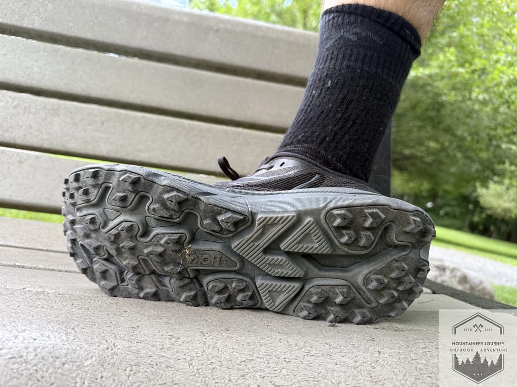 ull outsole view of the Hoka Challenger 8 featuring 4mm multi-directional lugs and Durabrasion rubber, designed for high-performance traction on both road and gravel surfaces.
