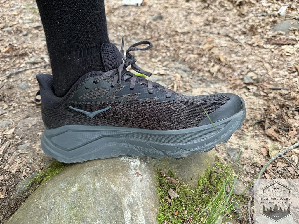 Testing the Hoka Challenger 8 protection on a sharp rock to evaluate the shock absorption of the high-stack CMEVA midsole on technical trail features.