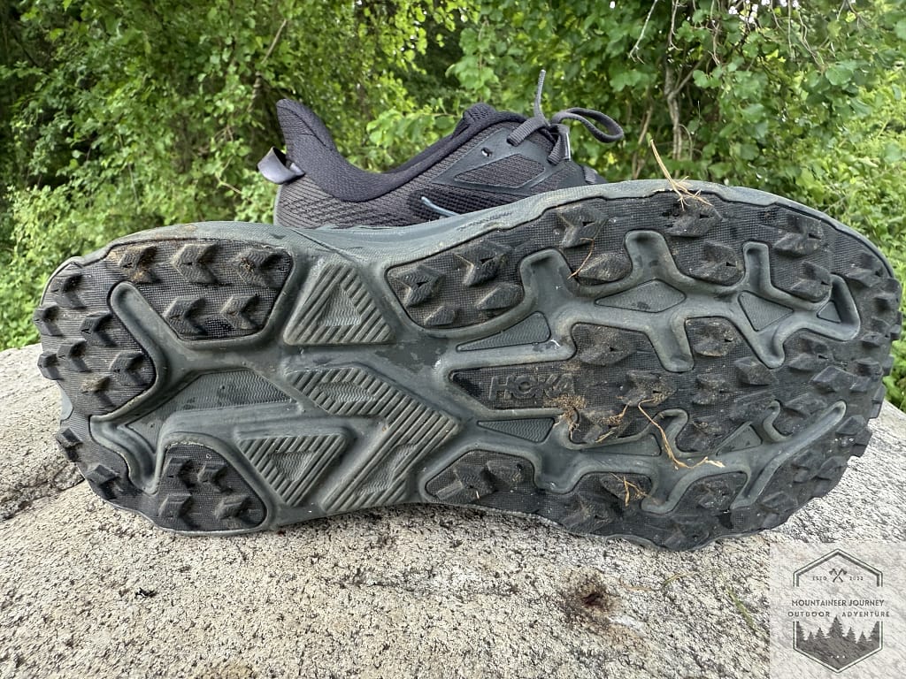 Close-up of the Hoka Challenger 8 Durabrasion rubber outsole, highlighting the redesigned multi-directional 4mm lugs for optimal grip on gravel and a smooth ride on pavement.