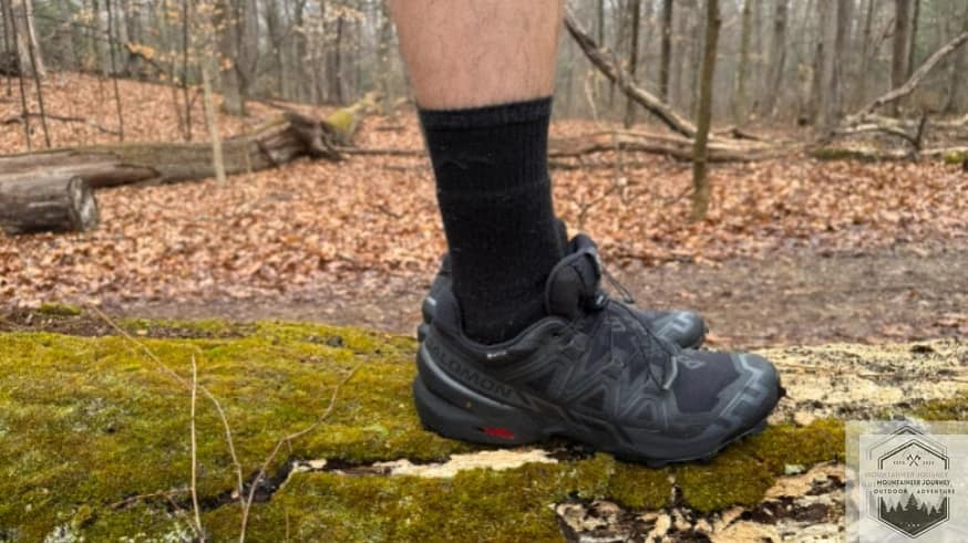 blog-img-1744747844304 Actively testing the Salomon Speedcross 6 stability on a fallen tree log to evaluate the shoe's lateral control and ground feel during technical off-trail maneuvers