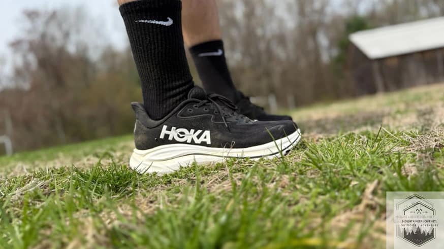 Side view of the hoka clifton 10, wearing in grass during testing