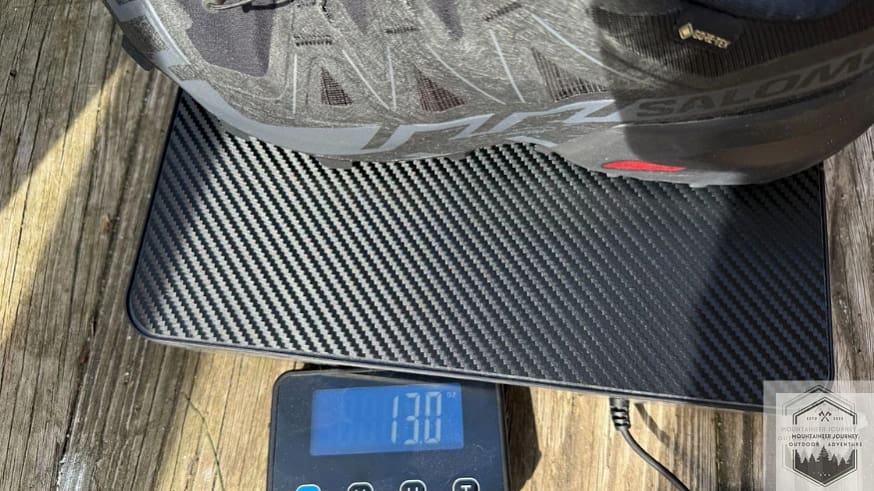 Weighing the Salomon Speedcross 6 on a digital scale at 13 oz providing verified technical specifications for this aggressive mountain trail runner.