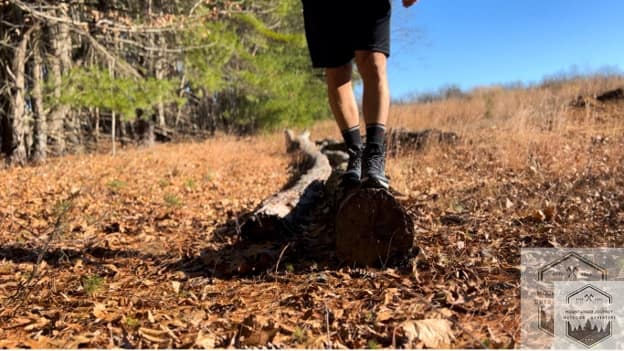 blog-img-1732723216899 standing on a log holding balance with the hiking shoes