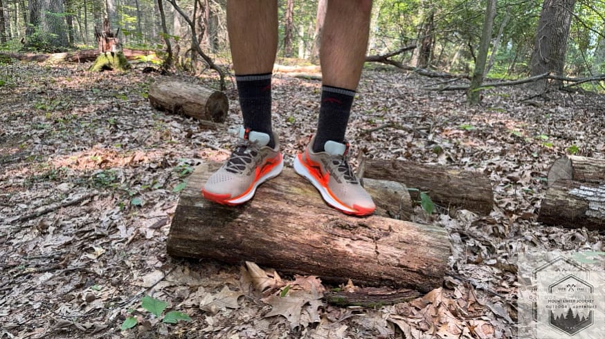 Standing on a log wearing the Nike Pegasus Trail 5, showing the stack height
