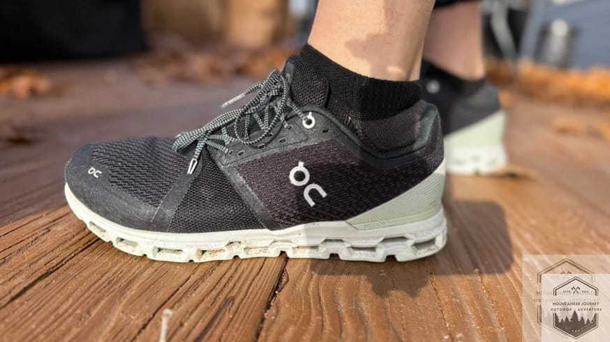 side profile view of the On Cloud 6 pair on a wood surface, highlighting the sleek urban design and the signature speed lacing system for easy travel and daily wear.