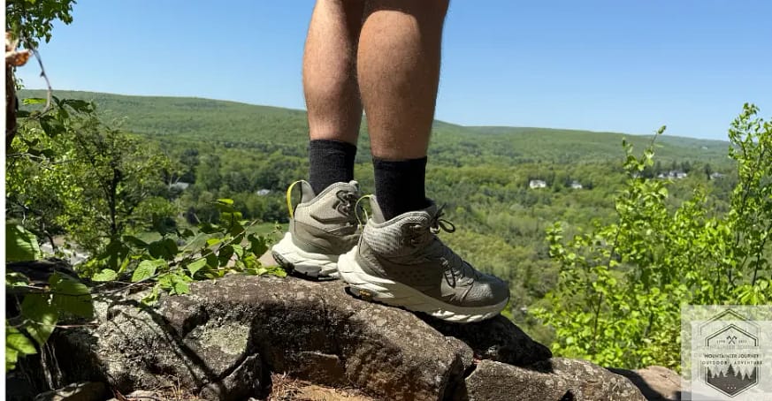wearing hiking boots on a rock, showing the "mid" portion of the boot