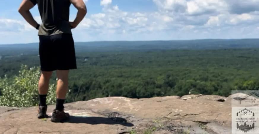 Summer Hiking Outfit: Moisture wicking shirt, shorts, summer hiking boots at the top of the summit