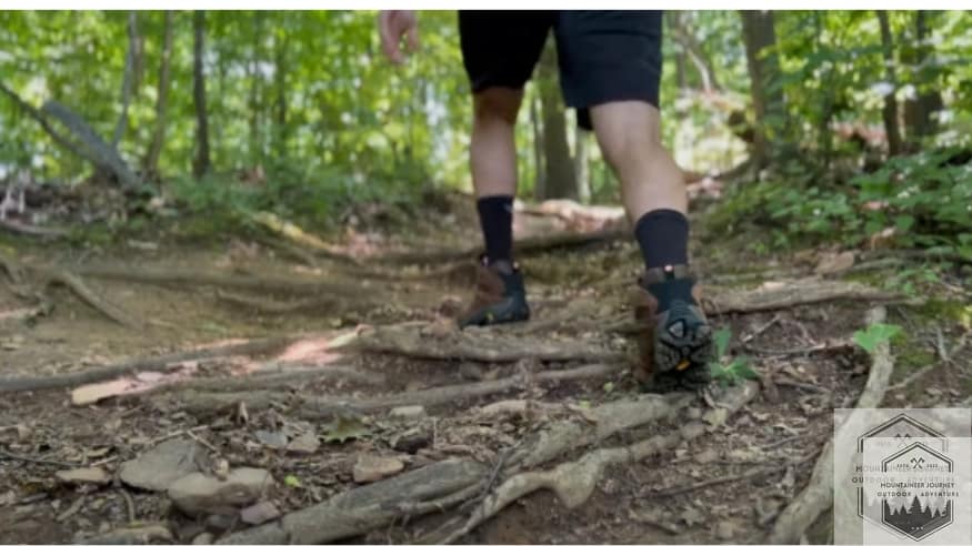 Merrell Moab 3 hiking boots on a uneven trail, showcasing their durability and design.