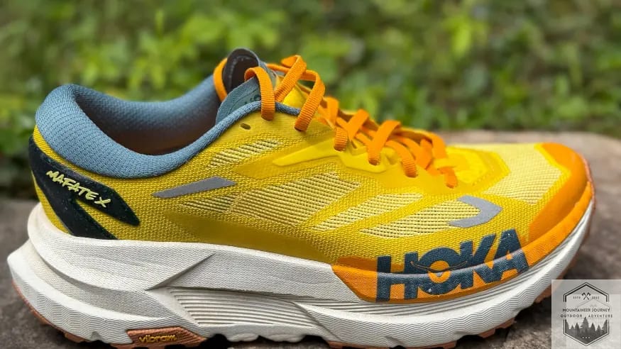 Side view of the Hoka Mafate X resting on a stone wall